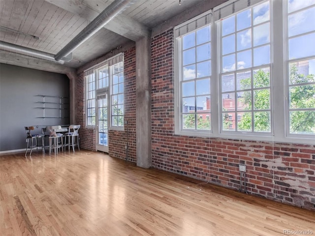 interior space featuring brick wall and wood finished floors