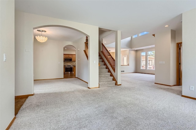 carpeted empty room featuring an inviting chandelier