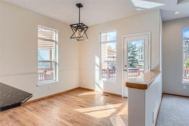 dining space with light wood-type flooring and an inviting chandelier