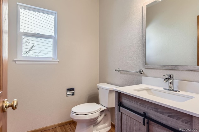 bathroom featuring wood-type flooring, vanity, and toilet