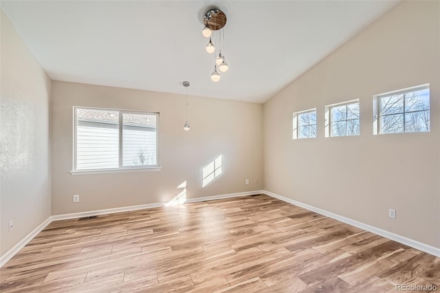 unfurnished room featuring light hardwood / wood-style floors and vaulted ceiling