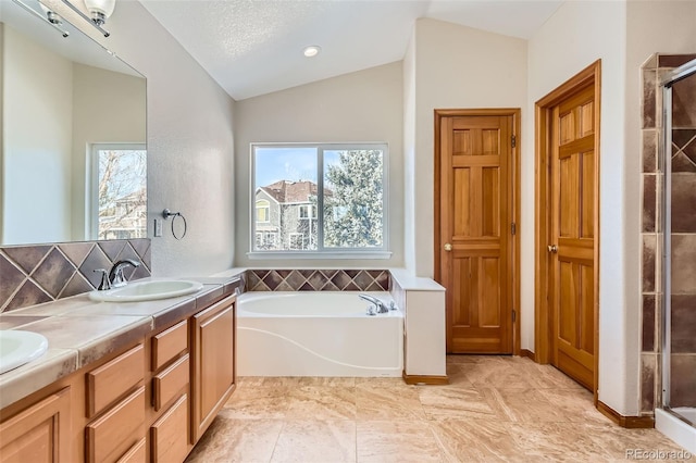 bathroom with a textured ceiling, vanity, independent shower and bath, and lofted ceiling