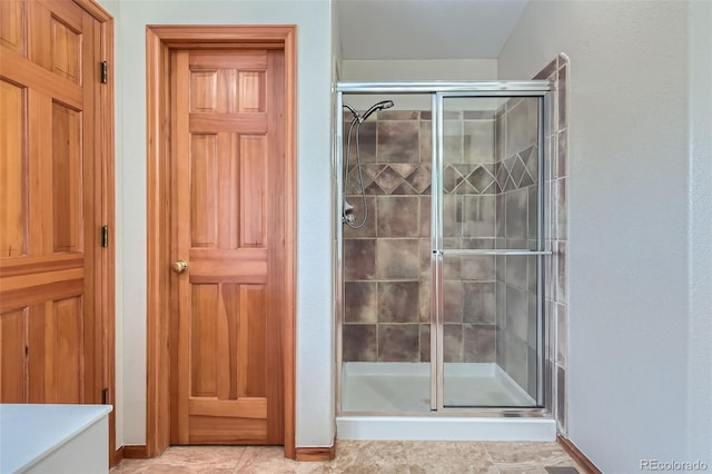 bathroom featuring tile patterned floors and a shower with shower door