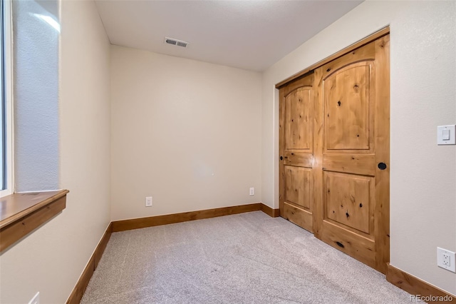 unfurnished bedroom featuring light carpet