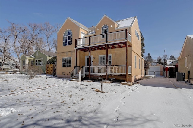 view of front of property featuring a balcony, a garage, central AC unit, and stucco siding