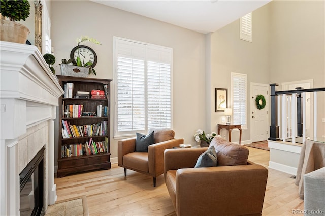 sitting room with baseboards, wood finished floors, and a tile fireplace