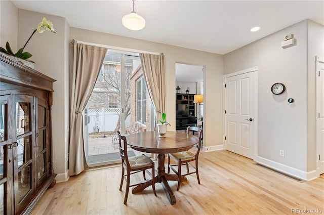 dining room featuring light wood-type flooring and baseboards