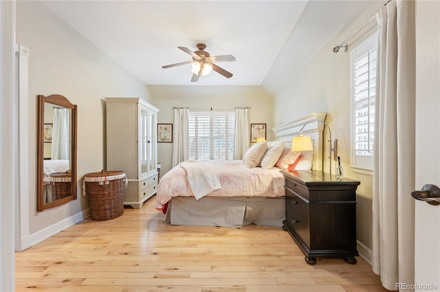 bedroom with a ceiling fan, vaulted ceiling, baseboards, and wood finished floors