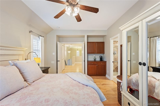 bedroom with light wood-style floors, ensuite bath, ceiling fan, and french doors