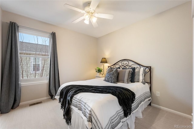 bedroom featuring baseboards, visible vents, a ceiling fan, and light colored carpet