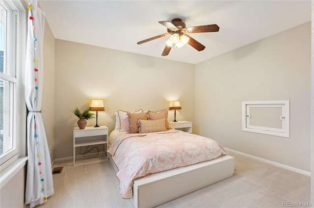 bedroom with baseboards, ceiling fan, and light colored carpet