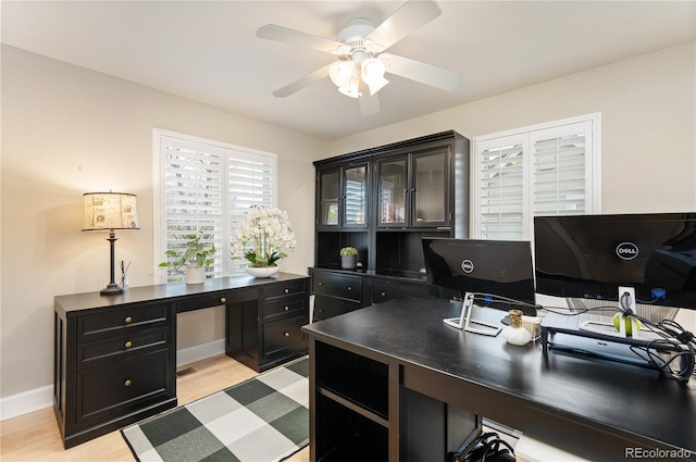 office area with ceiling fan, baseboards, and light wood-style flooring