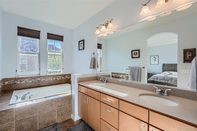 bathroom with vanity and tiled bath