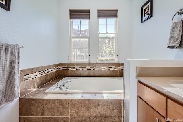 bathroom featuring vanity, a healthy amount of sunlight, and tiled bath