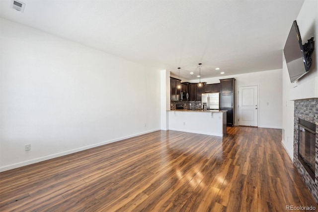 16285 W 62nd Ln Unit C, Arvada, CO 80403 - unfurnished living room with recessed lighting, a glass covered fireplace, dark wood finished floors, and baseboards