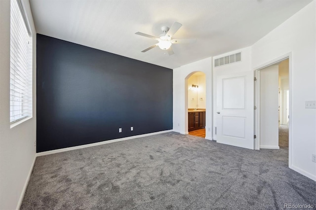 16285 W 62nd Ln Unit C, Arvada, CO 80403 - unfurnished bedroom with arched walkways, carpet flooring, a ceiling fan, and ensuite bath
