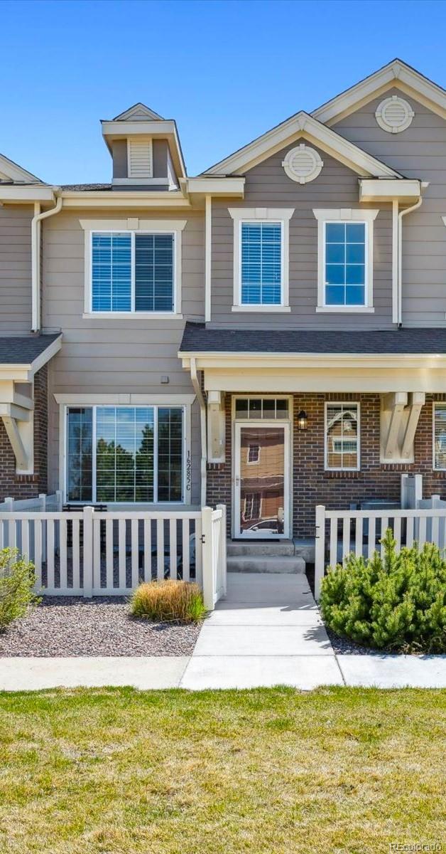 16285 W 62nd Ln Unit C, Arvada, CO 80403 - view of front facade featuring a fenced front yard and brick siding