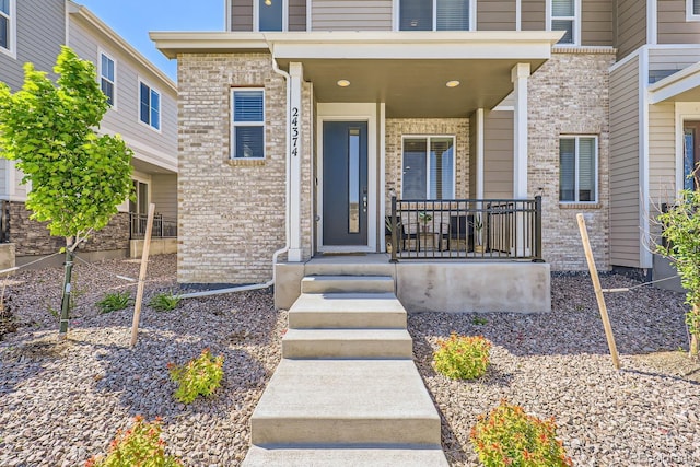 24374 E 42nd Ave, Aurora, CO 80019 - doorway to property featuring brick siding and a porch