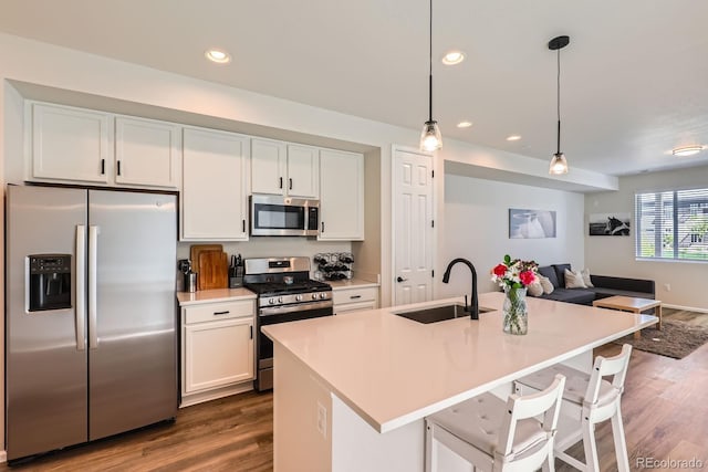 24374 E 42nd Ave, Aurora, CO 80019 - kitchen with stainless steel appliances, a sink, open floor plan, dark wood-style floors, and white cabinets