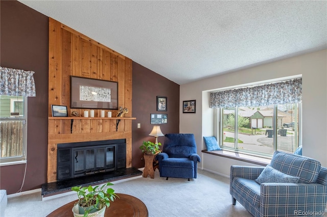 living area featuring a glass covered fireplace, carpet flooring, a textured ceiling, and lofted ceiling