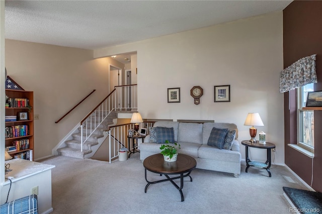 living area featuring baseboards, carpet flooring, and stairway