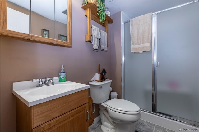 bathroom with toilet, a shower stall, tile patterned flooring, and vanity