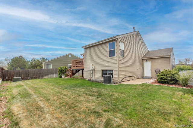 rear view of property with stairway, a yard, fence, and a wooden deck