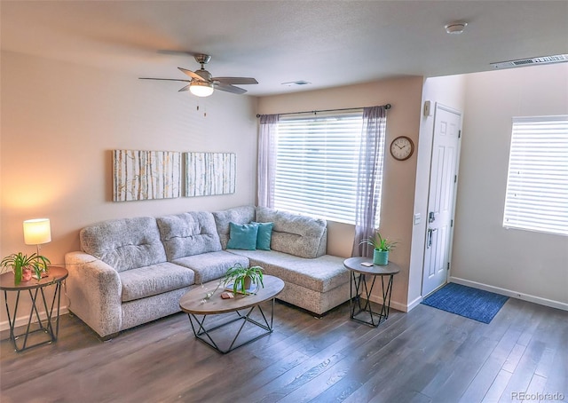 living area featuring baseboards, a ceiling fan, dark wood-style floors, and visible vents