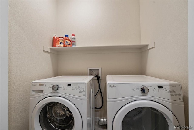 clothes washing area with washing machine and clothes dryer and laundry area