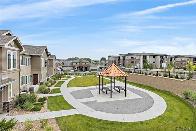 view of home's community with fence, a yard, and a residential view
