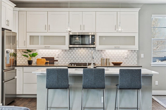 kitchen featuring appliances with stainless steel finishes, light countertops, dark wood finished floors, and backsplash