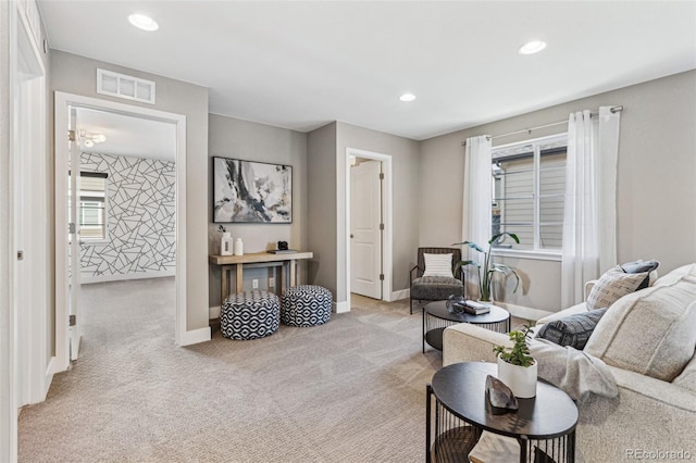 carpeted living area featuring baseboards, visible vents, and recessed lighting