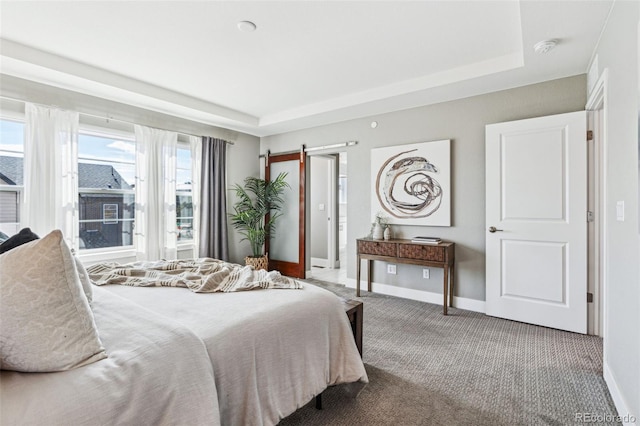 carpeted bedroom with a raised ceiling, baseboards, and a barn door