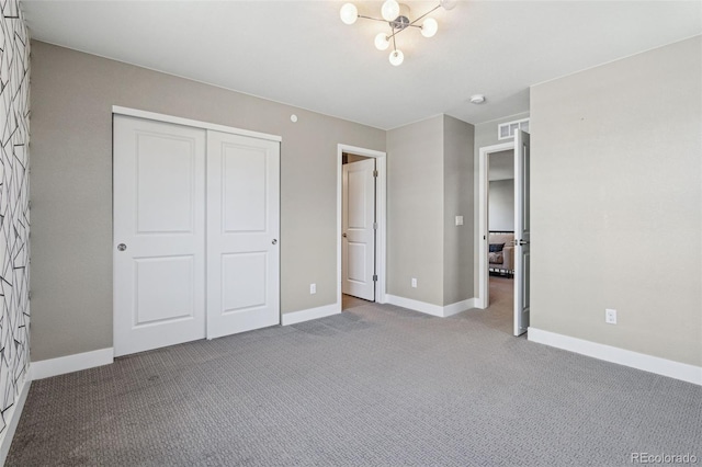 unfurnished bedroom with carpet floors, baseboards, visible vents, and a closet