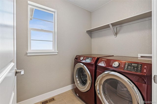 laundry room with washing machine and dryer, laundry area, visible vents, and light tile patterned floors