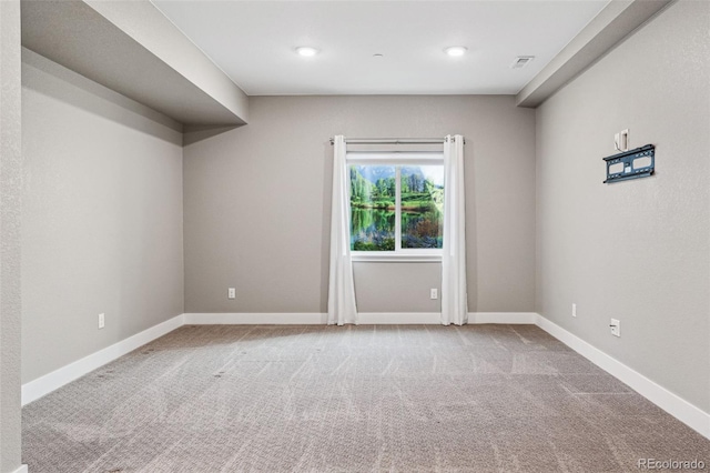 spare room with baseboards and carpet flooring