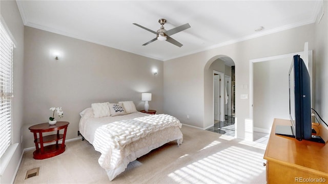 carpeted bedroom featuring visible vents, arched walkways, ornamental molding, and multiple windows