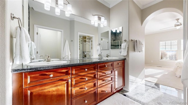full bath with a ceiling fan, a sink, double vanity, and crown molding
