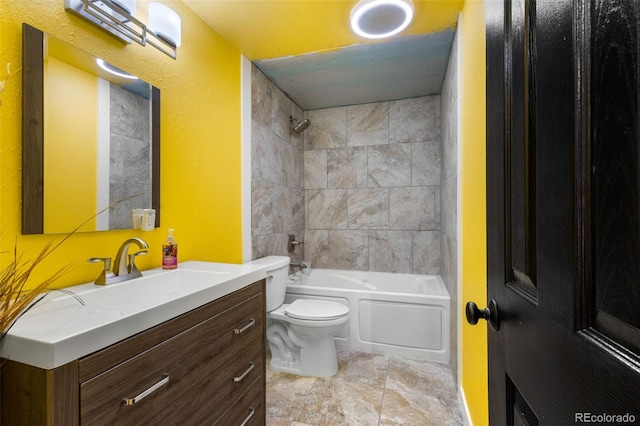 full bathroom with tile patterned flooring, toilet, tiled shower / bath combo, and vanity