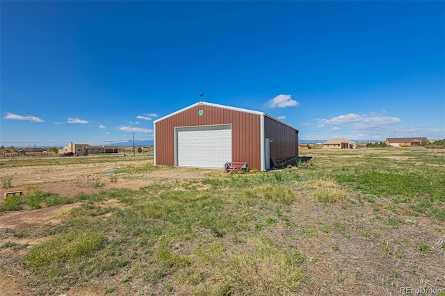 exterior space with a garage and a rural view