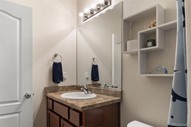 1836 Taos St, Brighton, CO 80603 - half bath featuring vanity, toilet, and a textured wall