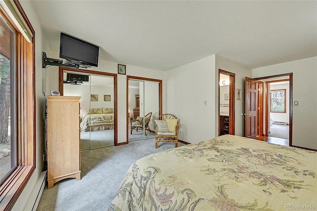 bedroom featuring carpet flooring, a baseboard radiator, and two closets