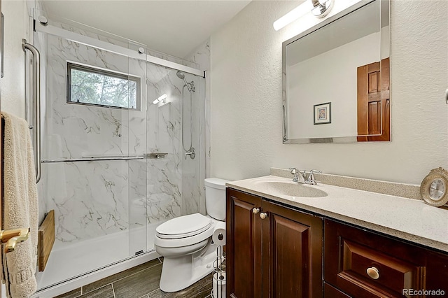 bathroom with a shower with door, vanity, tile patterned flooring, and toilet