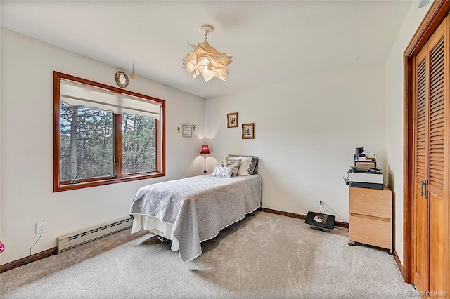 carpeted bedroom featuring a baseboard heating unit and a closet