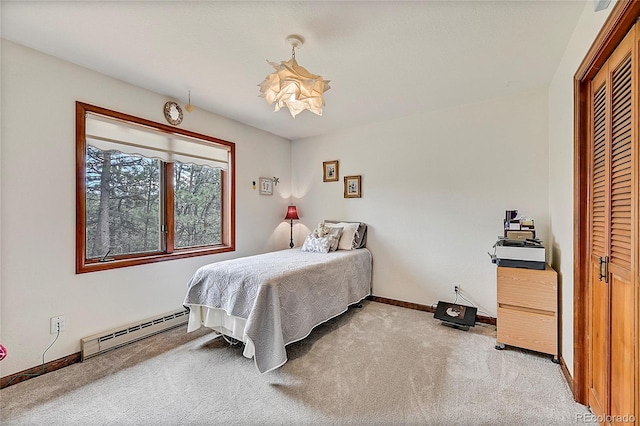 bedroom featuring baseboard heating, carpet, and a closet