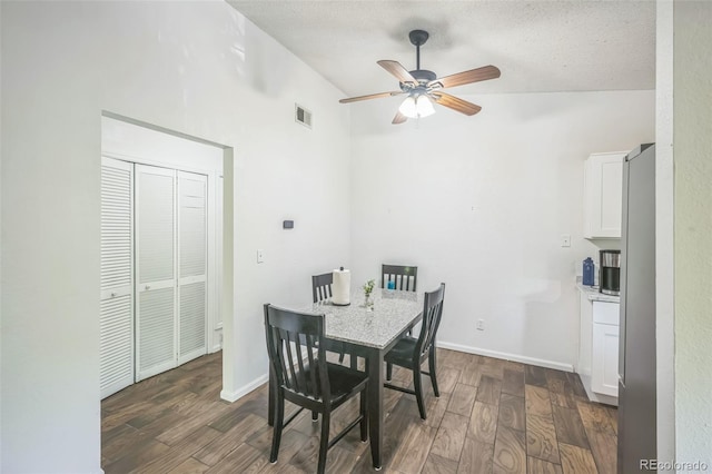 1111 S Garrison St Unit 202, Lakewood, CO 80232 - dining room featuring dark wood-style flooring, ceiling fan, lofted ceiling, a textured ceiling, and baseboards