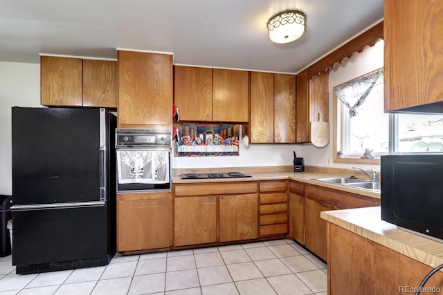 kitchen featuring light tile patterned floors, sink, and black appliances