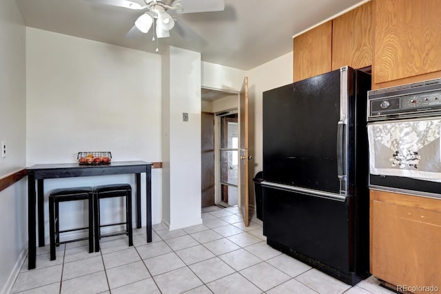 kitchen featuring black appliances, ceiling fan, and light tile patterned floors