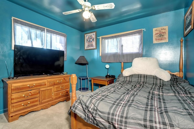 bedroom with light carpet, multiple windows, and ceiling fan