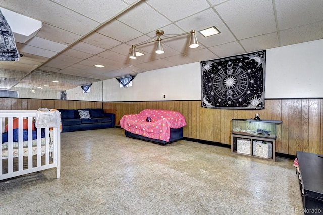 bedroom with a paneled ceiling and wooden walls